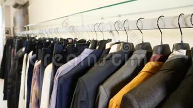 在服装店。 排男女服装.. 衣架上的夹克，牛仔裤和衬衫。 收集新的美丽